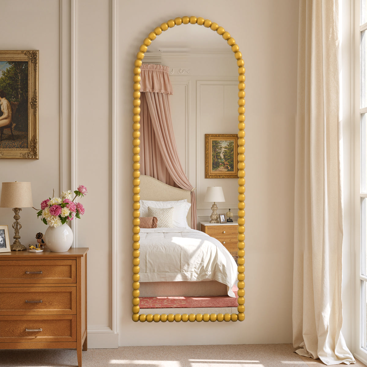 Delphine antique gold beaded arched full-length mirror in a bedroom