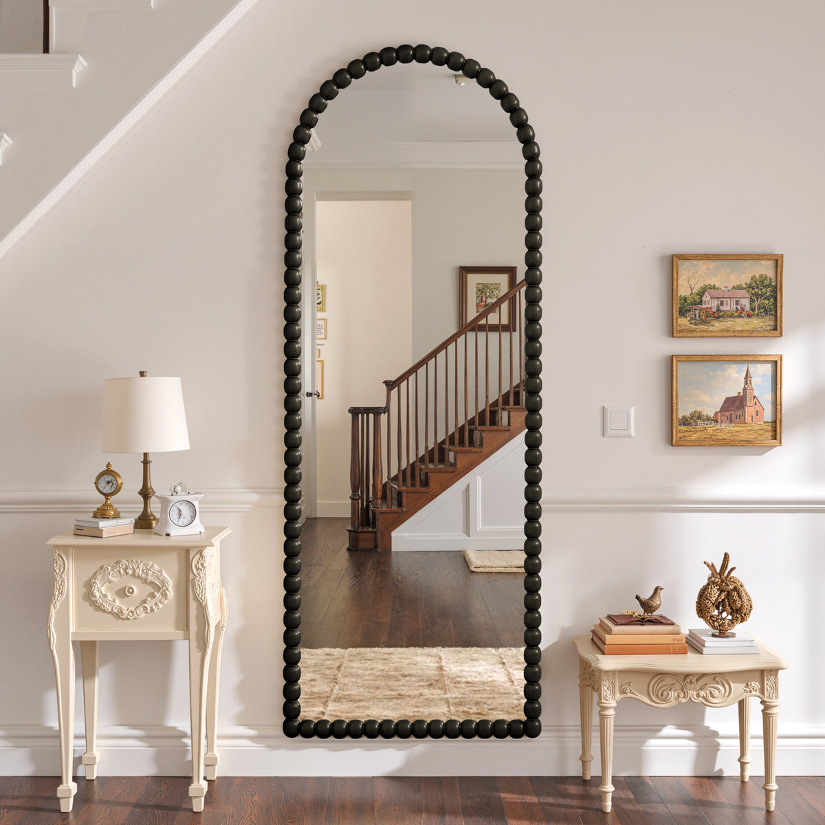 Delphine black beaded arched mirror mounted in a hallway