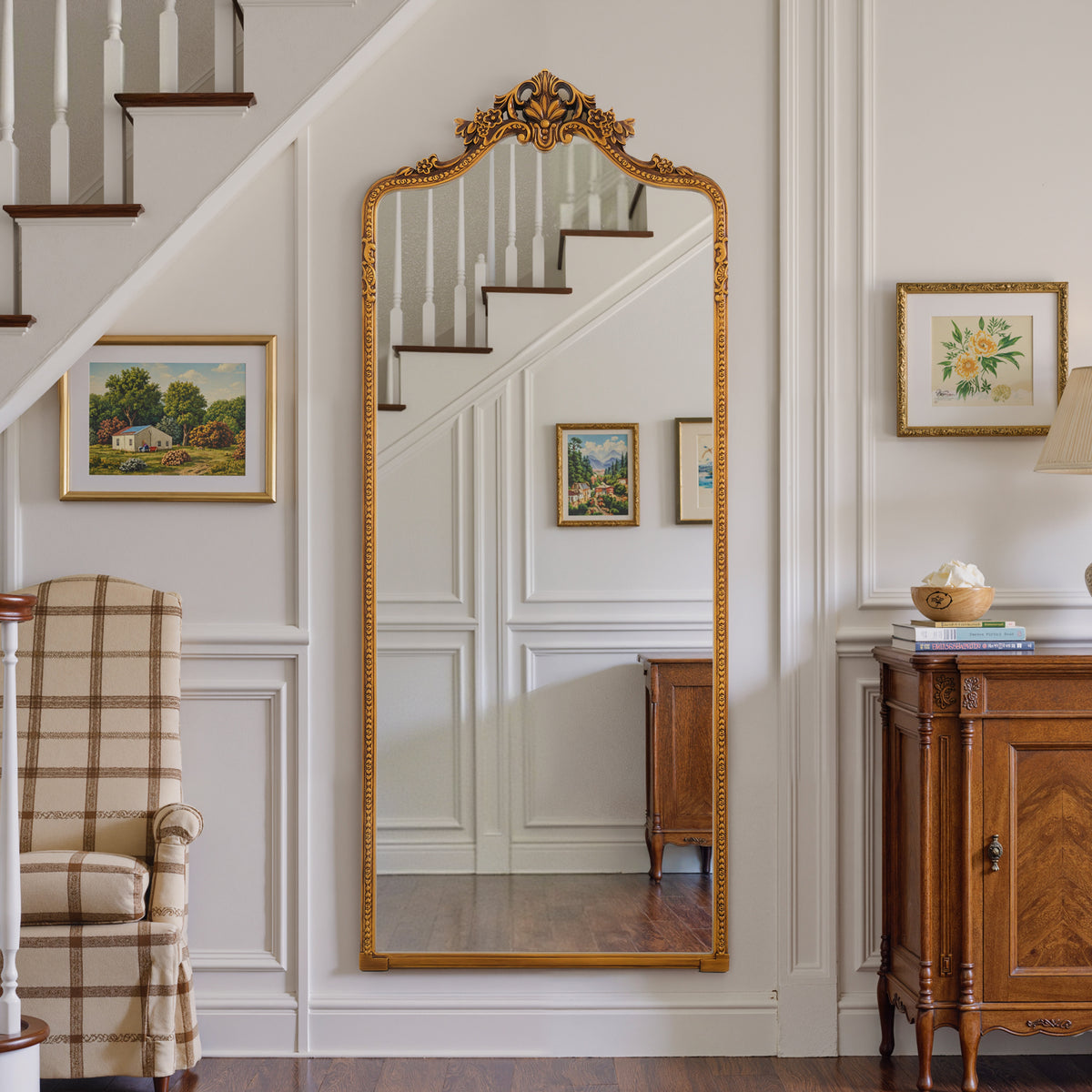 Vivienne antique gold floral crest mirror mounted in a hallway