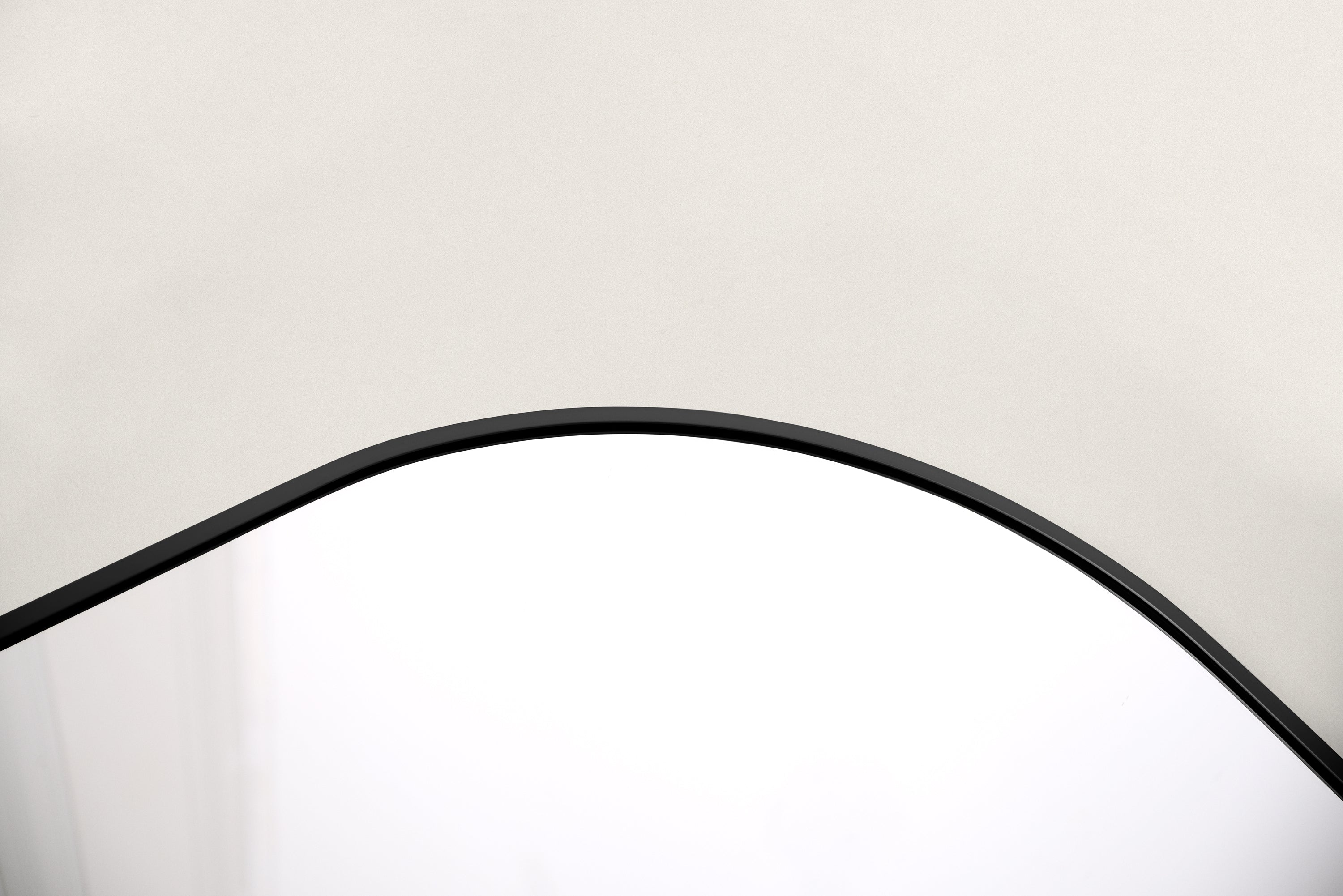 Close-up of the slim curved black aluminum frame on the Elliot full-length mirror