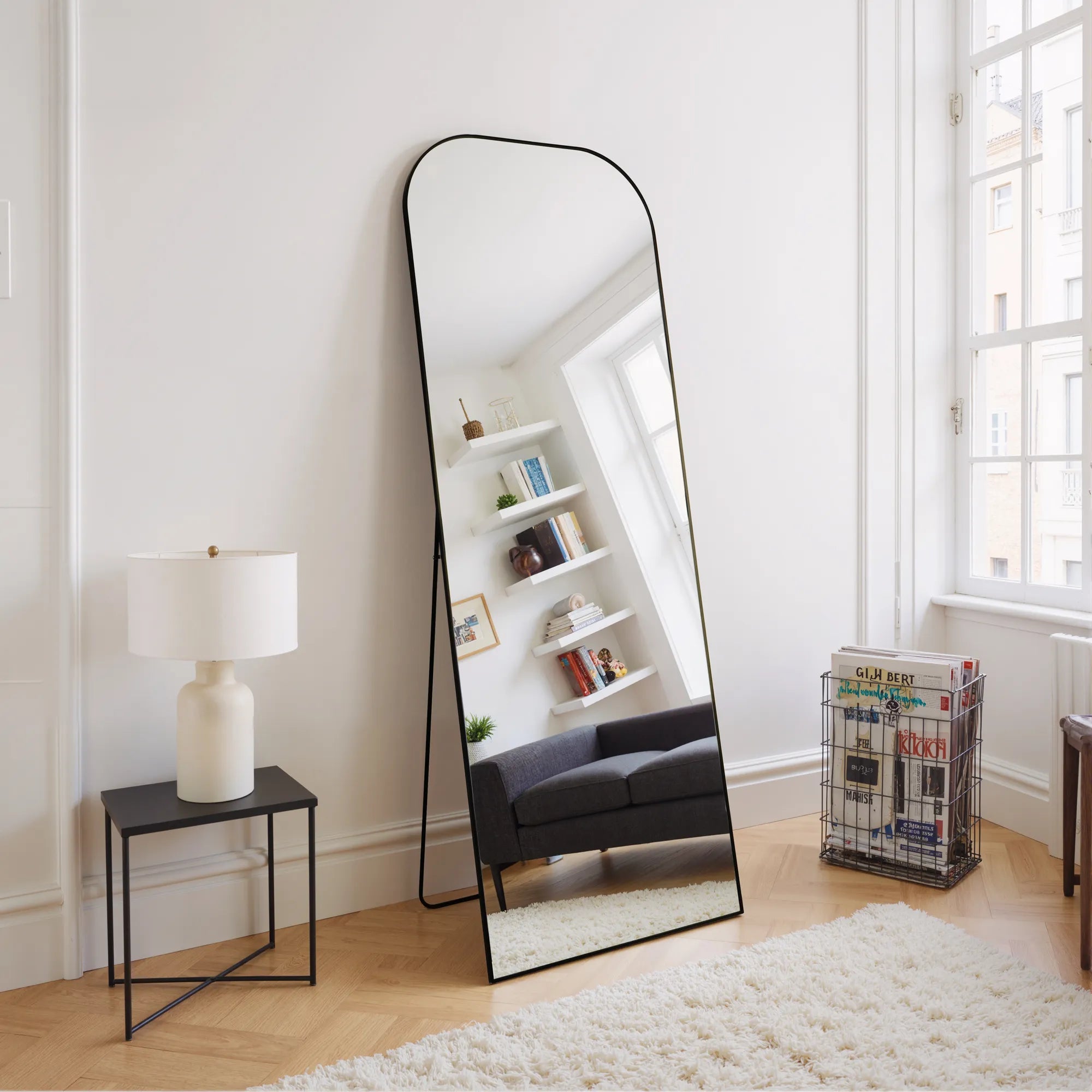 Elliot black curved full-length mirror standing in a bright living room