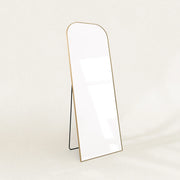 Elliot gold curved full-length mirror on its folding stand