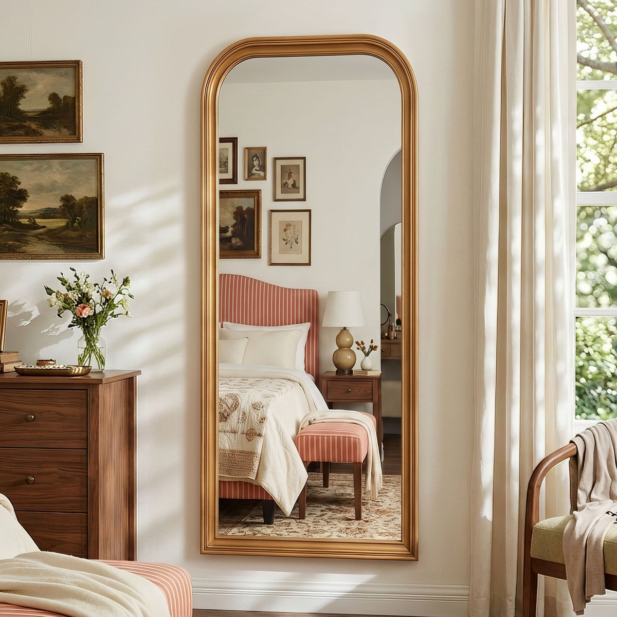 Estelle antique gold full-length mirror mounted on a bedroom wall