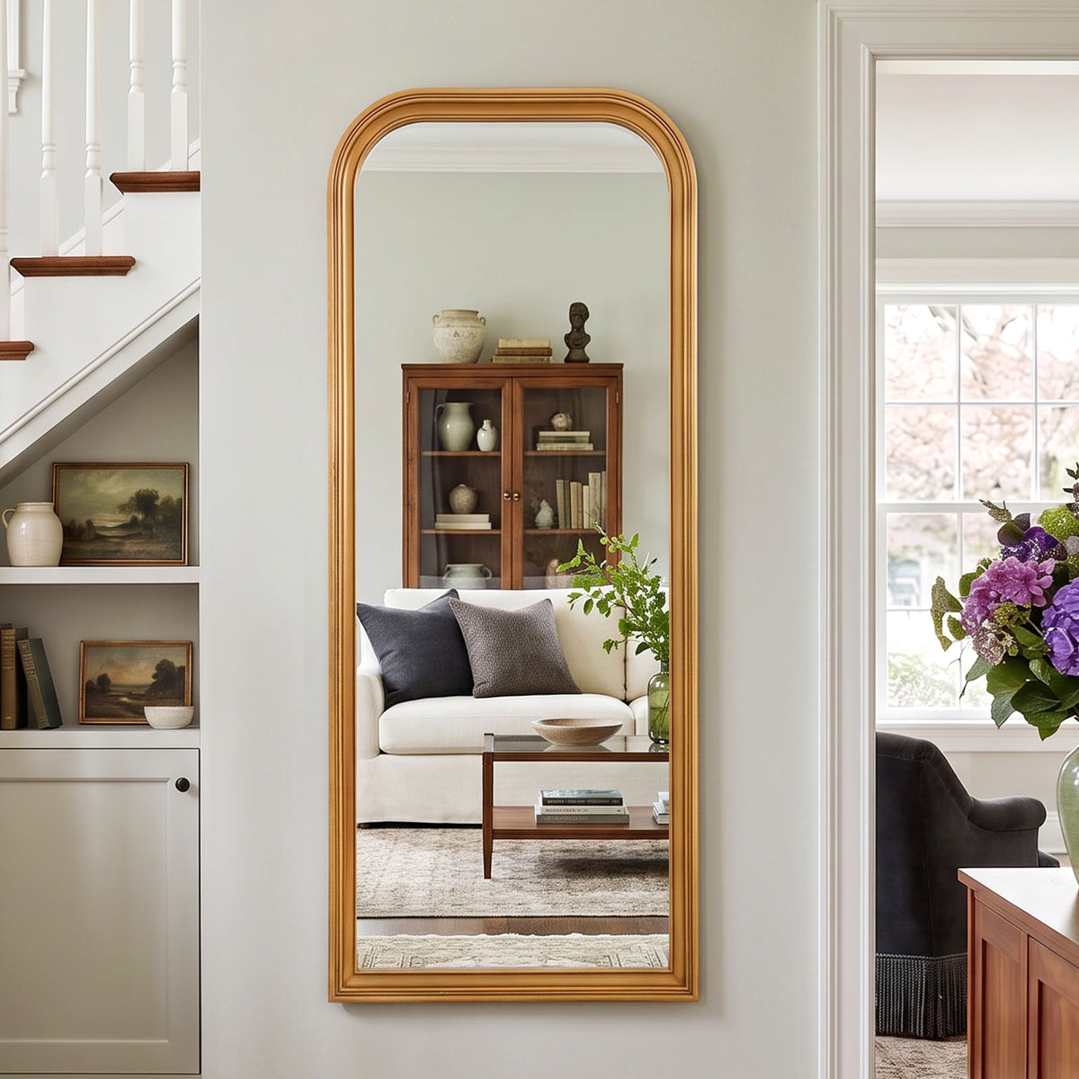 Estelle antique gold full-length mirror mounted beside a staircase