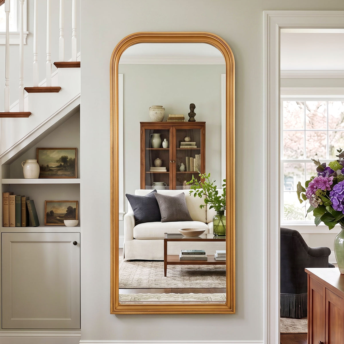 Estelle antique gold full-length mirror mounted beside a staircase