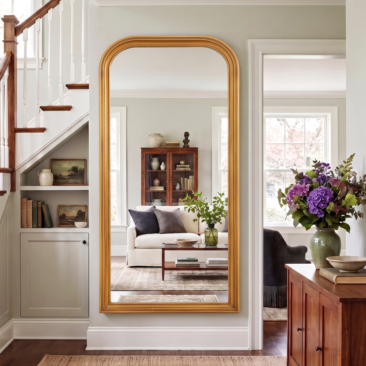 Estelle antique gold full-length mirror mounted beside a staircase