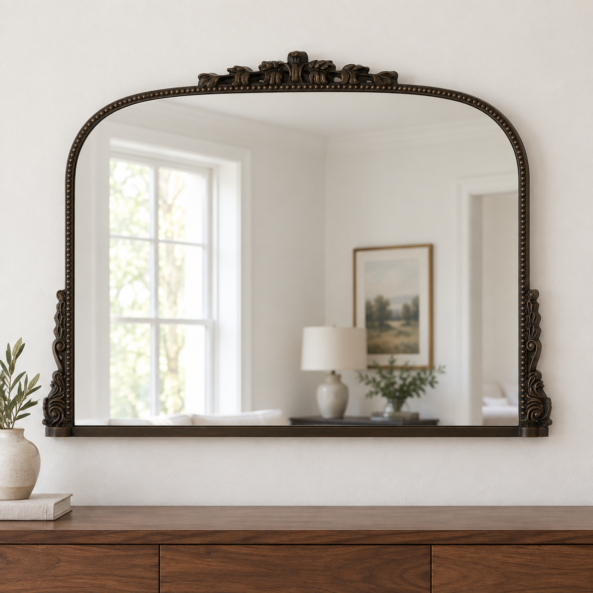 Harriet antique bronze ornate wall mirror above a wooden console in a vintage-inspired interior