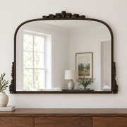 Harriet antique bronze ornate wall mirror above a wooden console in a vintage-inspired interior