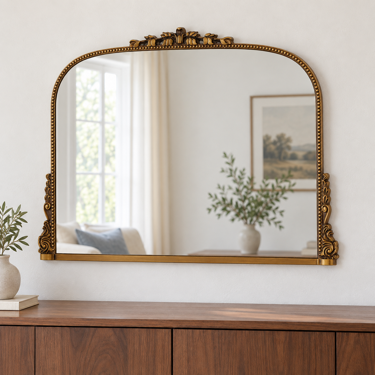 Harriet antique gold ornate wall mirror above a wooden console in a vintage-inspired interior